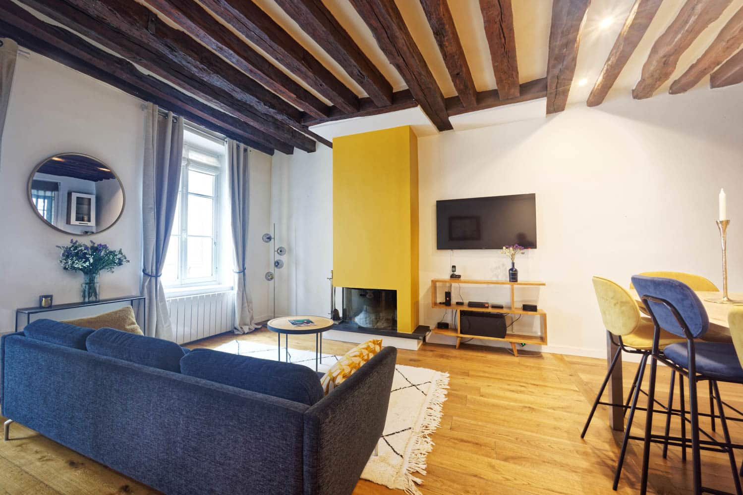 salle à manger avec cheminée et poutres apparentes