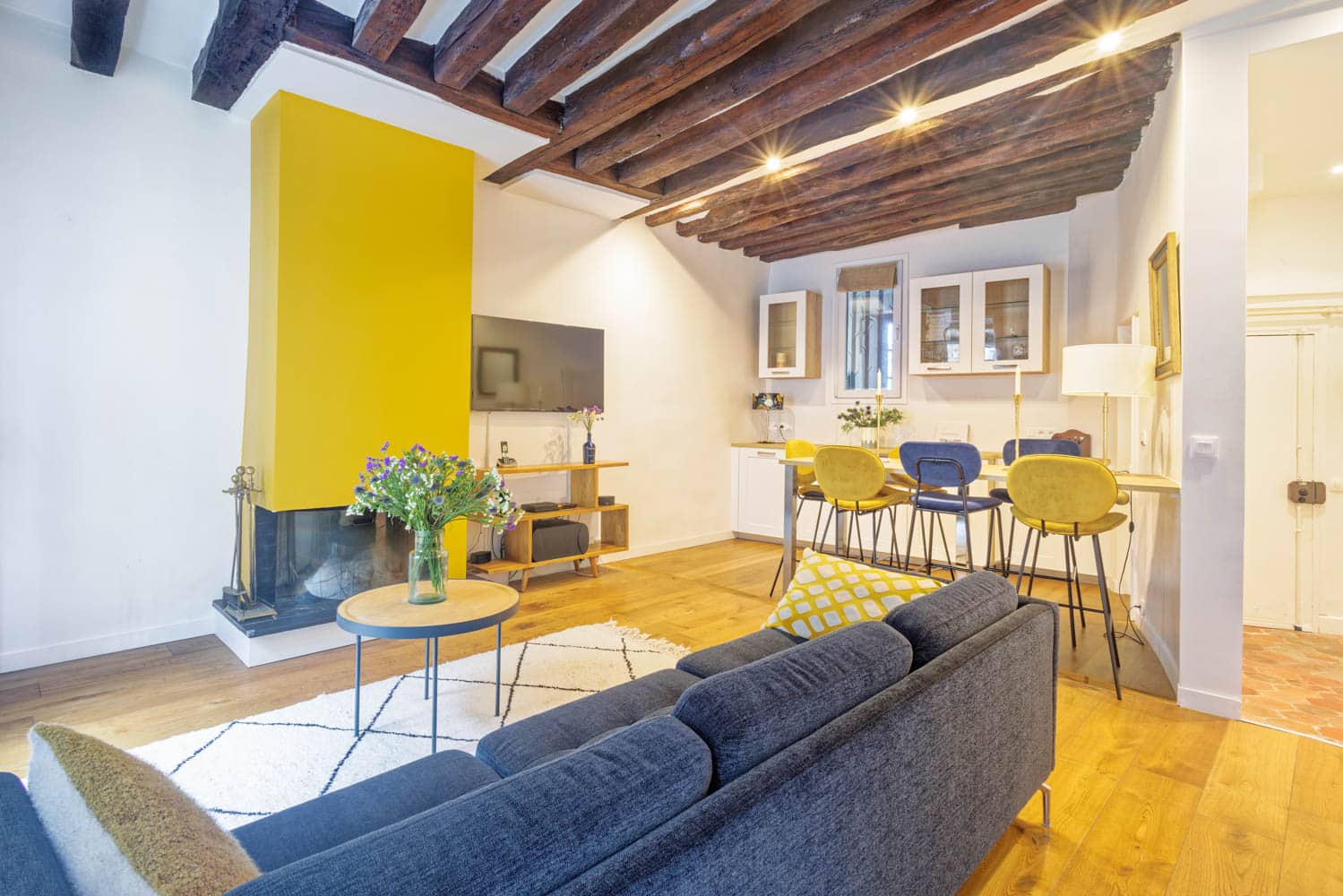 salle à manger avec cheminée et poutres apparentes